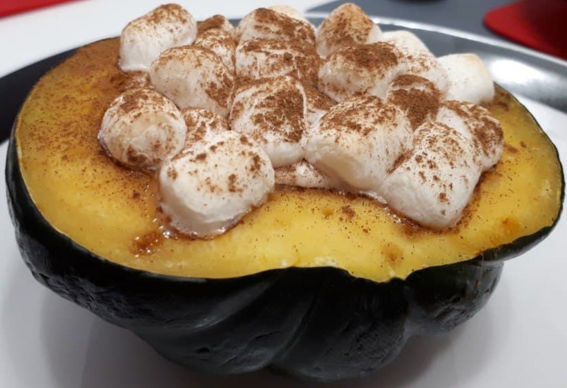 Marshmallow Pecan Stuffed Acorn Squash with a sprinlking of cinnamon powder on top