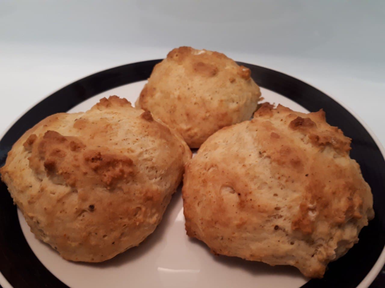 Three Mayonnaise Biscuits served on a small white plate with a black border