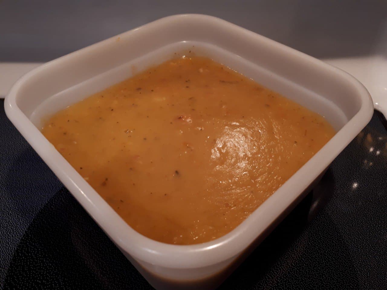 Québécois-Style Yellow Split Pea Soup with Bacon portioned out into a white plastic container