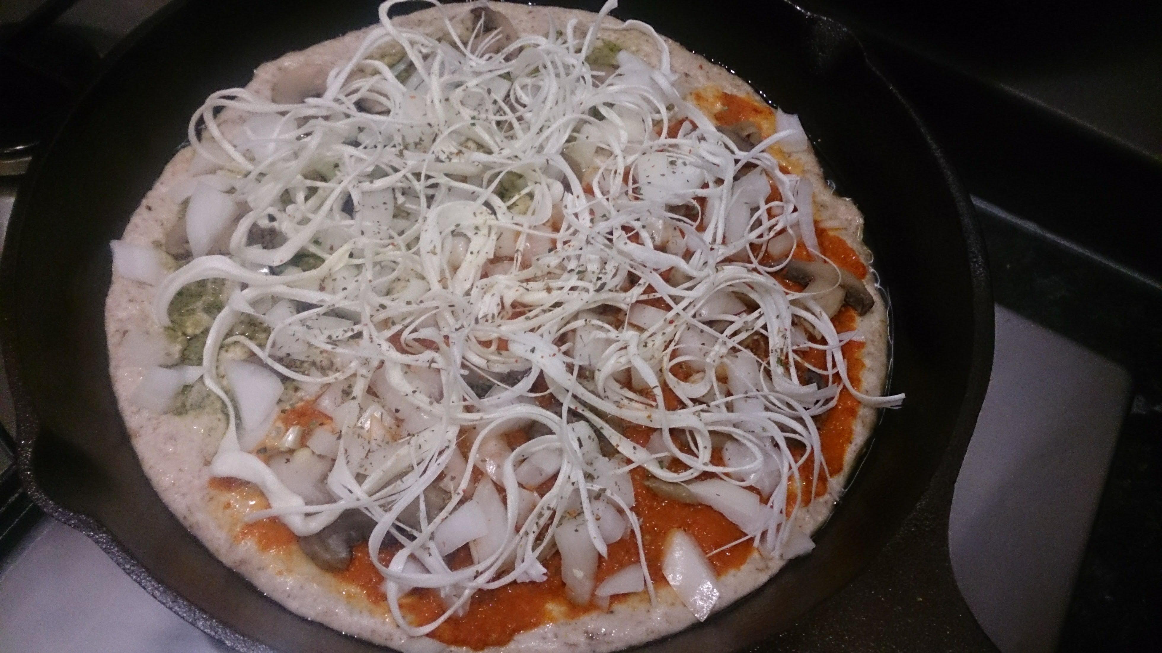 Cooked cast iron pan pizza on a white cutting board