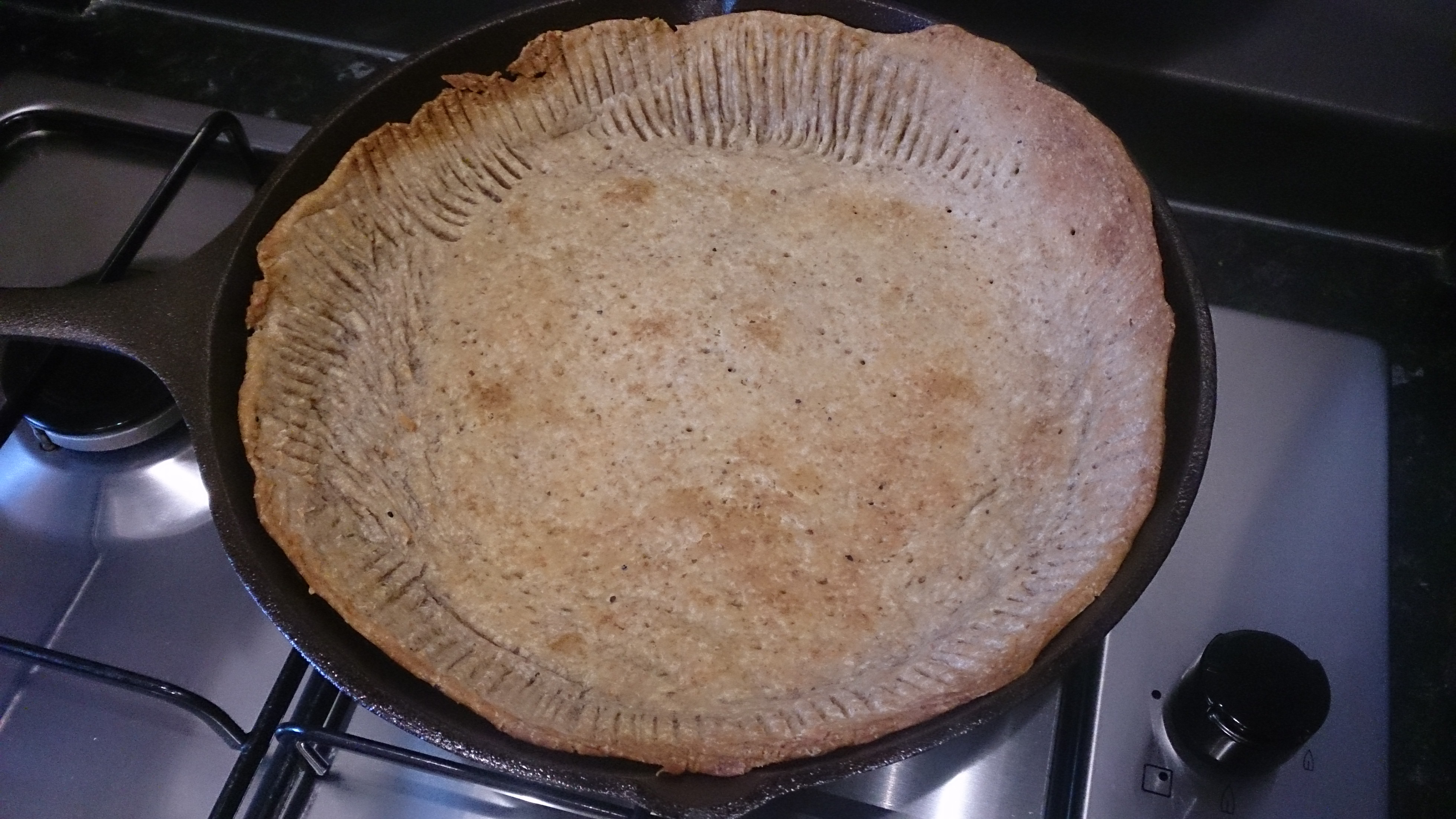 Empty quiche pastry in a cast iron frying pan