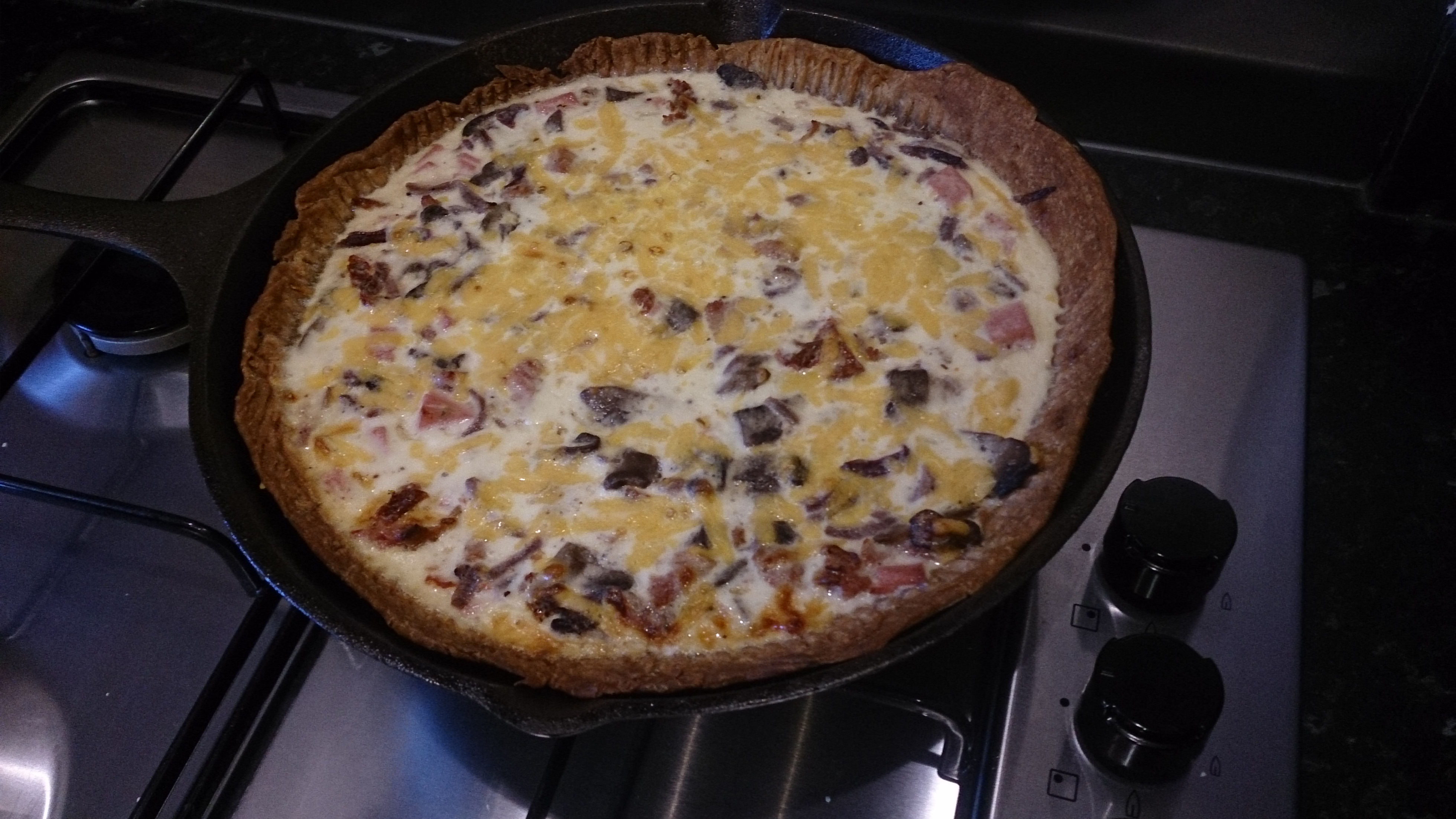 Uncooked quiche in a cast iron frying pan